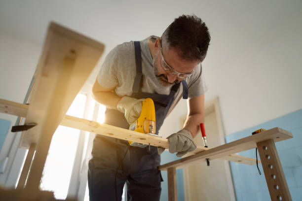 istock Caucasian carpenter using jigsaw to cut the timber 1390310608