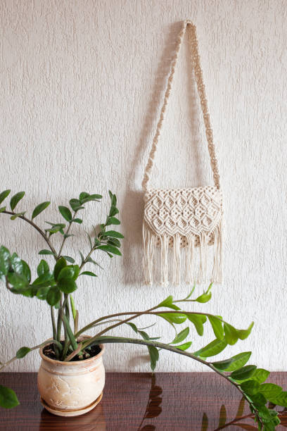 istock Handmade macrame bag  on the light wall. ECO friendly natural macrame cotton bag. Hobby knitting handmade macrame. Modern summer concept. Copy space 1390312041