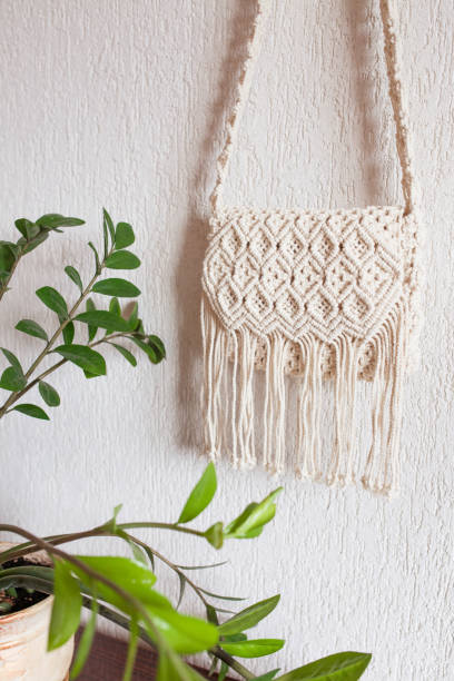 istock Handmade macrame bag  on the light wall. ECO friendly natural macrame cotton bag. Hobby knitting handmade macrame. Modern summer concept. Copy space 1390312050