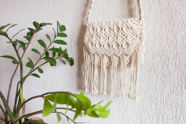 istock Handmade macrame bag  on the light wall. ECO friendly natural macrame cotton bag. Hobby knitting handmade macrame. Modern summer concept. Copy space 1390312051
