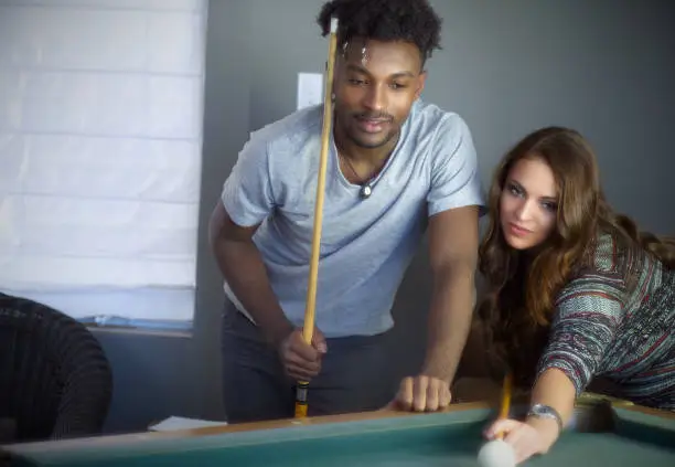 young women and men portrait team playing pool table billiards players fun activity recreation bar ball game