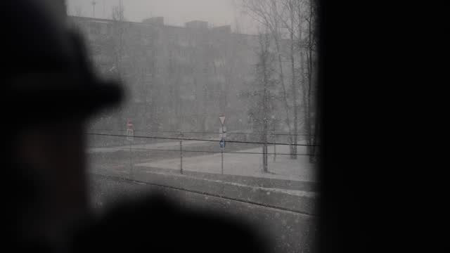 The camera captures the bad weather outside olknom where it is snowing heavily. Cool slow-motion shots in the city
