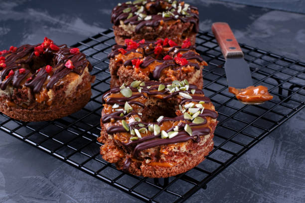 Donut shaped cakes with caramel, chocolate, pumpkin seeds and goji berries