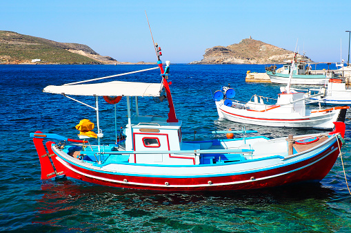 traditional fishing boat (or caïque) moored in the port of Panormos, pretty white port of Tinos, famous island of the Cyclades, in the heart of the Aegean Sea.