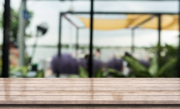 istock Empty wooden table top with lights bokeh on blur restaurant background. 1390317694