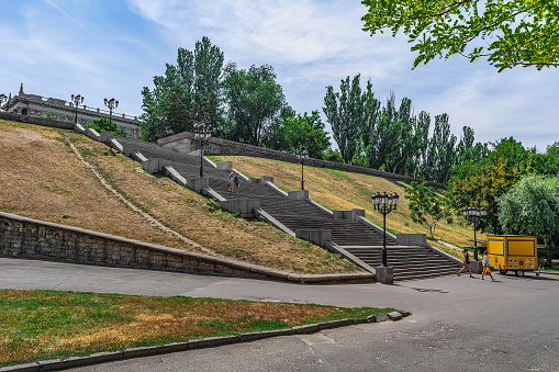 Mykolaiv, Ukraine - July 26, 2020: City staircase on Bulvar Flotskiy Boulevard in Mykolayiv. People go down the stone steps to the embankment