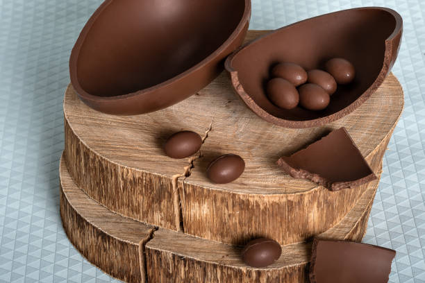istock chocolate egg, on a rustic wooden board, small chocolate eggs in one half of the chocolate egg, easter 1390319763