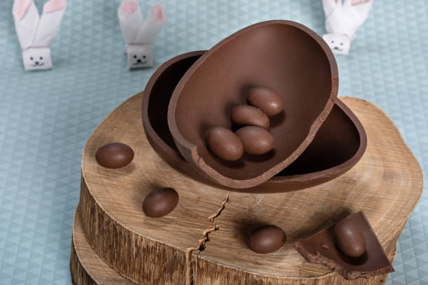istock chocolate egg, on a rustic wooden board, small chocolate eggs in one half of the chocolate egg, easter 1390319766