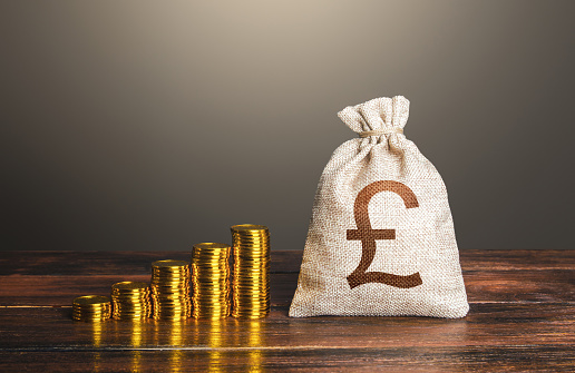 British pound sterling money bag and increasing stacks of coins. Rise in profits, budget fees. Investments. Raise incomes, increase salaries. Financial success. Bonus. Economic growth, GDP. Savings