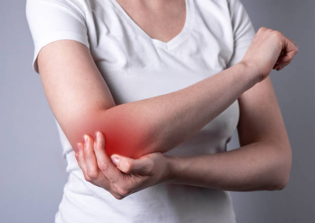 kobieta cierpiąca na ból łokcia i trzymająca bolesną rękę z czerwonym punktem zbliżenia. uraz ręki. problemy zdrowotne, medycyna, koncepcja leczenia. - pain elbow physical therapy inflammation zdjęcia i obrazy z banku zdjęć
