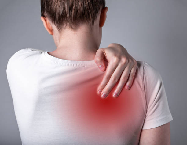 Woman suffering from shoulder blade pain. Trigger point. Hand holding shoulder with red spot closeup. Back injury. Health care, medicine concept Woman suffering from shoulder blade pain. Trigger point. Hand holding shoulder with red spot closeup. Back injury. Health care, medicine concept. High quality photo scapula stock pictures, royalty-free photos & images