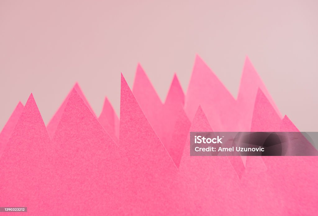 Mountains or market volatility creative minimal concept made of pink color sheet of paper on a light pastel background with copy space. Volatile Stock Photo