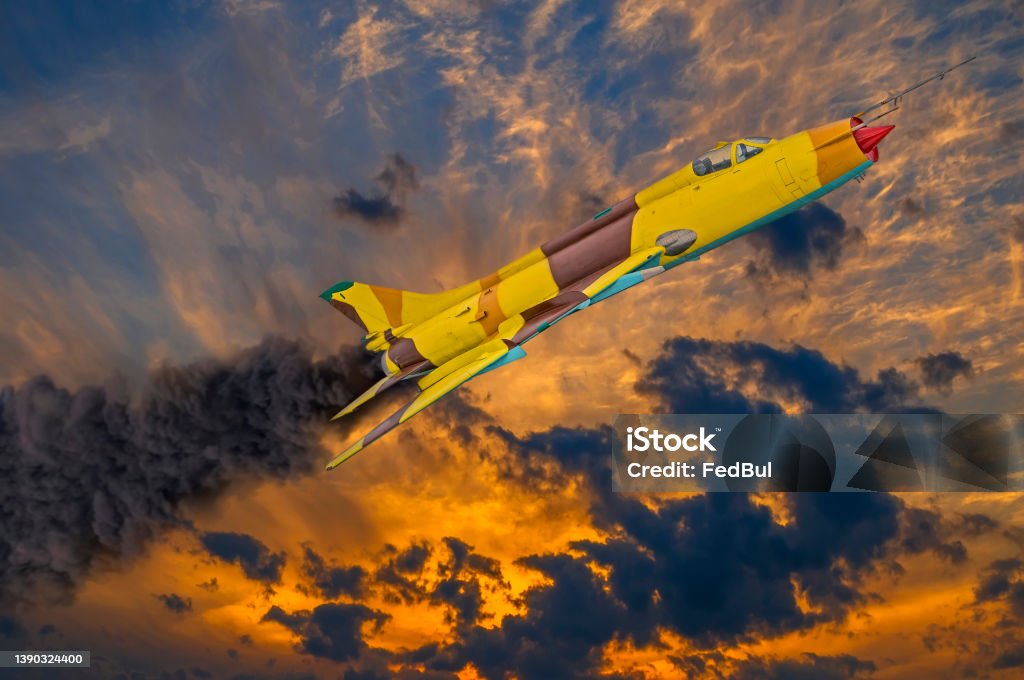 Jet fighter with engine on fire and smoke before crash in dramatic sunset sky. Military strike aircraft of World war time. Accidents and Disasters Stock Photo