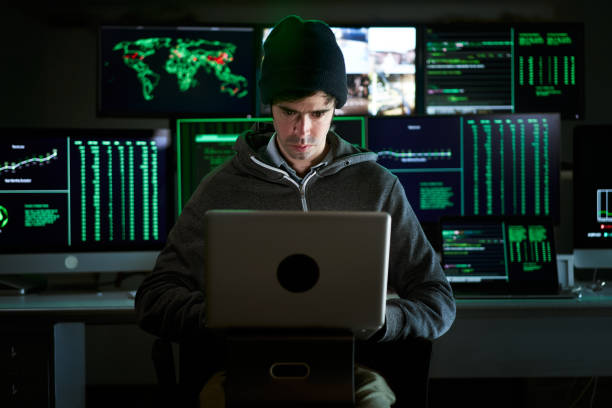 istock Front Shot from to Hacker Breaking into Corporate Data Servers from His Underground Hideout. Place has dark atmosphere, multiple displays 1390324454