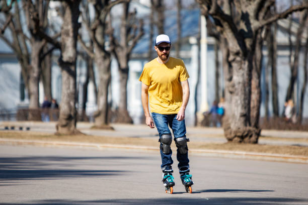 Young adult man roller skating alone in public park