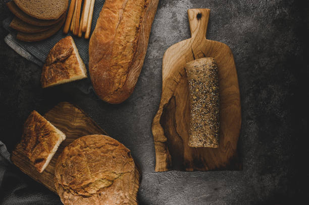 istock fresh rustic bread on a wooden cutting board. Copy spase text. Different types of bread on a gray concrete table. 1390325685