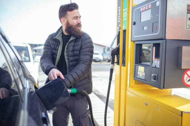 When it was his turn, the man refueled at the gas station. ISL stock photo