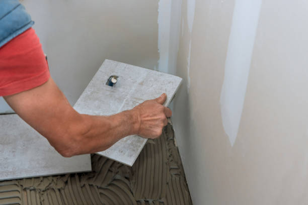 istock Workers hands with applying tile adhesive to the floor process of laying ceramic tiles 1390326459