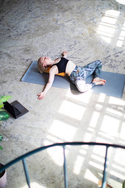 istock Young woman practicing yoga online with laptop 1390330383