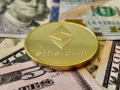 Ethereum on U.S Currency Background. Digital currency used for verified transactions while  maintaining a digital record in  a decentralized system using cryptography, rather than by a centralized authority.