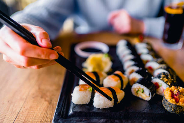 istock Eating sushi with chopsticks at sushi restaurant 1390334932