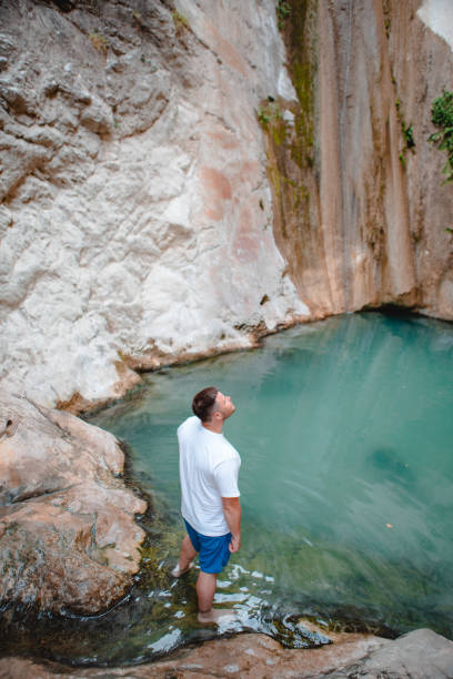 istock man traveler looking at dimosari waterfall lake at summer time 1390334973