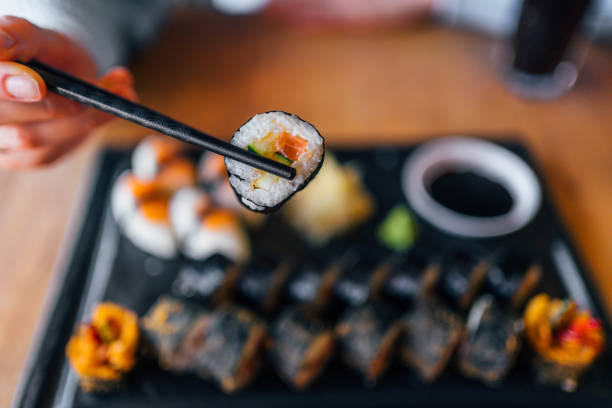 istock Eating sushi with chopsticks at sushi restaurant 1390335062