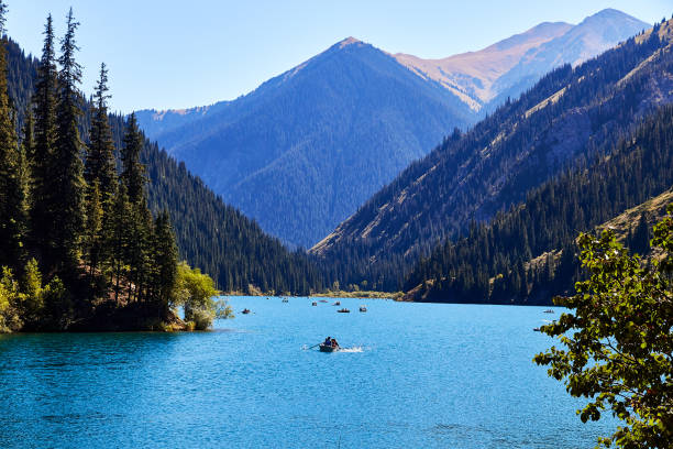 blick auf einen bergsee umgeben von wald - kasachstan stock-fotos und bilder