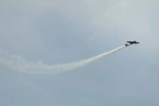 Aerial acrobatics stunt flying plane. Airplane with smoke in the sky for air show.