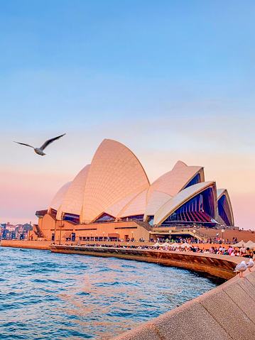 Tourists are enjoying Sydney Harbour and the Opera House scene at dusk in Sydney, Australia.