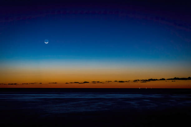 Sunrise with moon over the sea