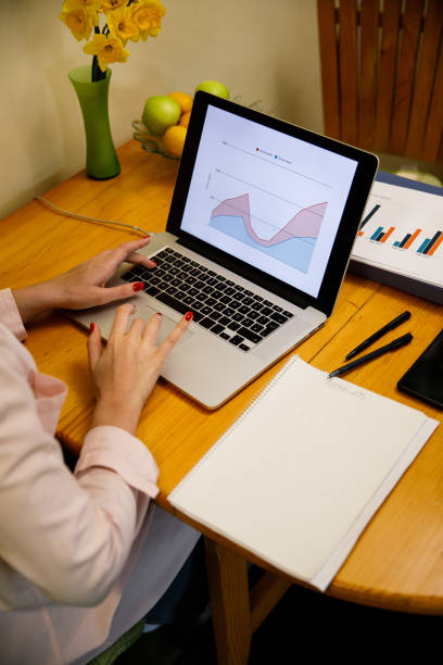 istock High angle view of unrecognizable businesswoman using laptop, making a graph 1390346684