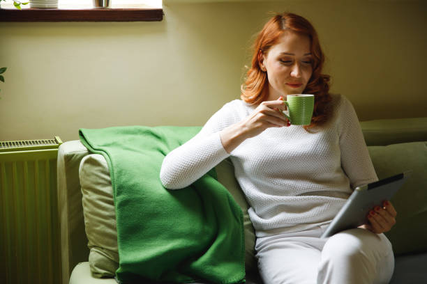 istock Copy space shot of young woman sipping coffee and using digital tablet for fun while relaxing 1390349324