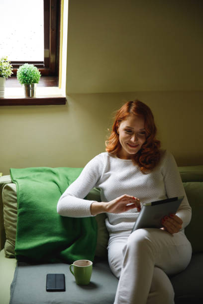 istock Scrolling through social media via digital tablet while relaxing on the sofa 1390349326