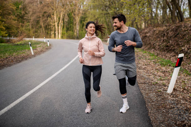 istock Happy athletic couple having fun while running in spring day 1390350333
