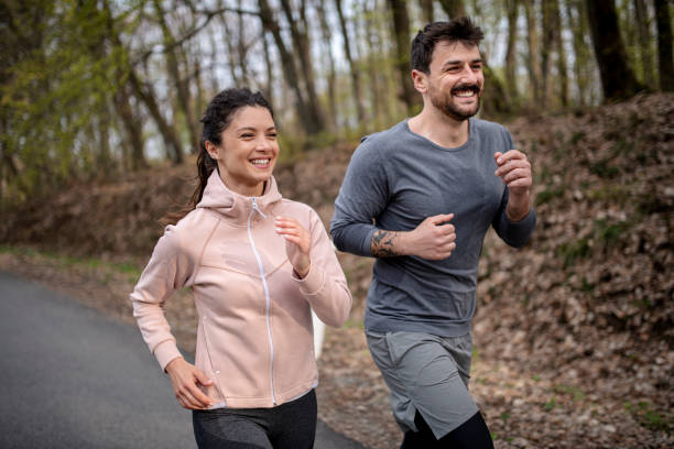 istock Happy athletic couple having fun while running in spring day 1390351043