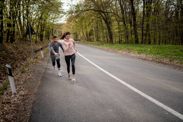 istock Happy athletic couple having fun while running in spring day 1390351219