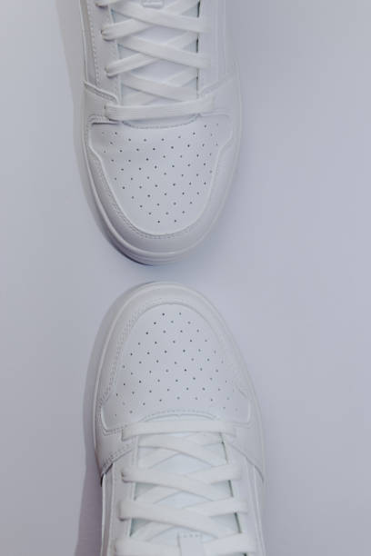 istock Top view of two white sneakers on a white background - vertical 1390351920