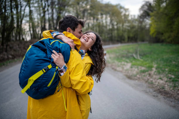 istock Happy affectionate couple in raincoats enjoying in nature 1390351965