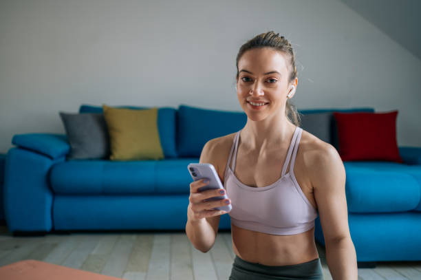 istock Woman using airpods and a smartphone while training at home 1390353420