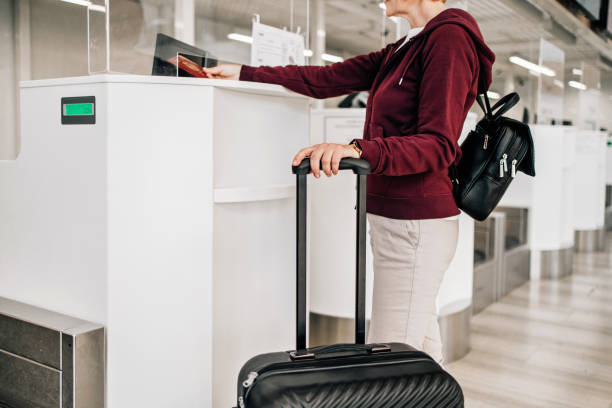 rear elevated view of motion blurred unrecognizable travellers pulling luggages, white background with copyspace