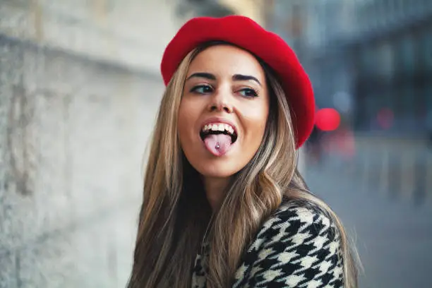 Photo of Young woman sticking out tongue