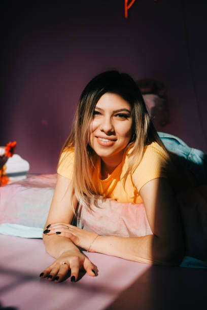 istock Young attractive caucasian woman relaxing on a bed in sunlight. 1390373635