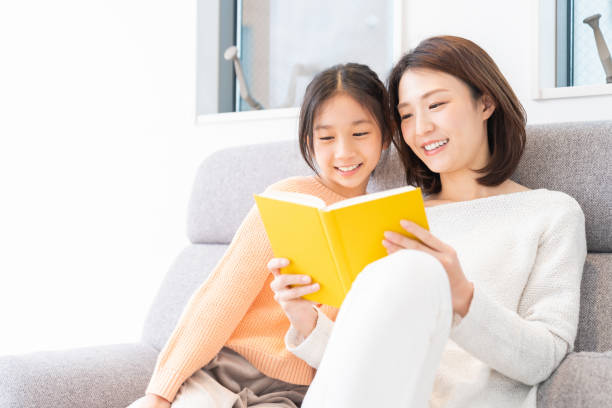 parent and daughter who reads a book asian parent and daughter who reads a book child japanese culture japan asian ethnicity stock pictures, royalty-free photos & images