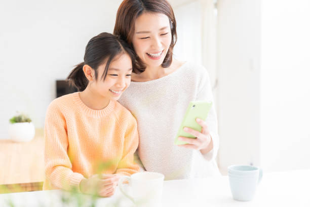 istock asian mother and daughter,smart phone 1390377432