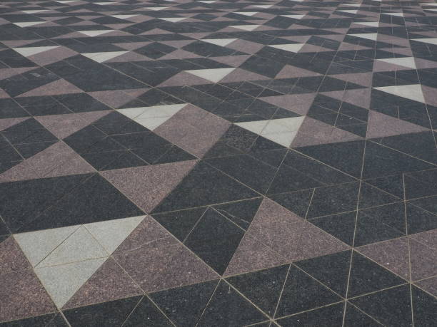 istock The square is paved with triangular tiles. Grey, white, black tiles on the street. The cobblestone surface. Modern design of streets, avenues, squares, shopping centers. Wear-resistant flooring. 1390378081