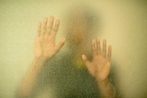 Close-Up Of Hand On Glass Window