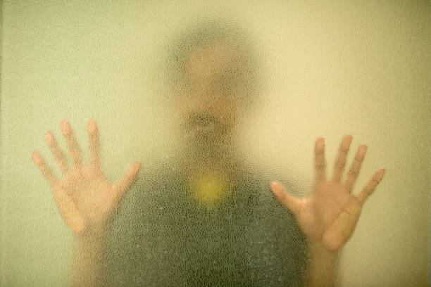 Close-Up Of Hand On Glass Window