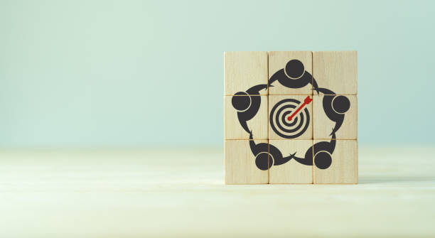 Common goal setting and success concept. Teamwork collaboration for achieving goal and successful business. Initiation for planning to reach target. Darts target aim, teamwork icon on wooden cubes. establecimiento de objetivos comunes y concepto de éxito. colaboración en equipo para lograr el objetivo y el éxito del negocio. iniciación para la planificación para alcanzar el objetivo. objetivo de los dardos, icono de trabajo en equipo en cubos de