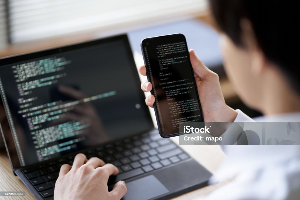 Asian programmer checking the operation of the code Python - Programming Language Stock Photo